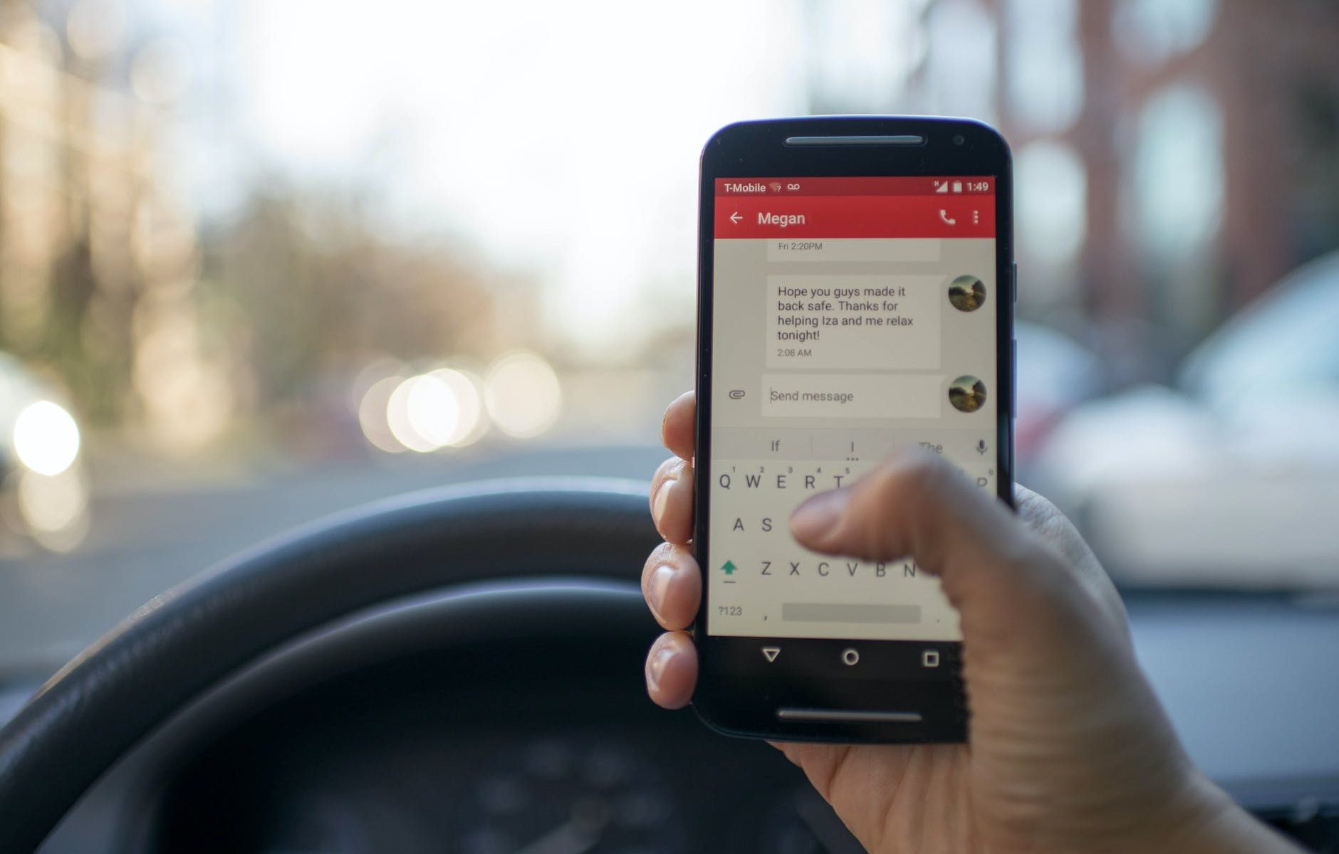 person sitting inside car with black android smartphone turned on